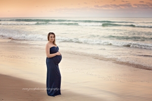 The beach at sunset maternity photo using an eden elizabeth gown
